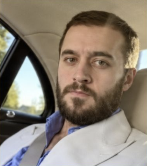 Евгений Зайферт в светлом пиджаке в салоне автомобиля